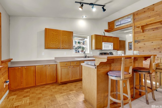 14865 N Red Rock Rd, Reno, NV 89508 - kitchen featuring white microwave, a sink, a kitchen bar, light countertops, and wood walls