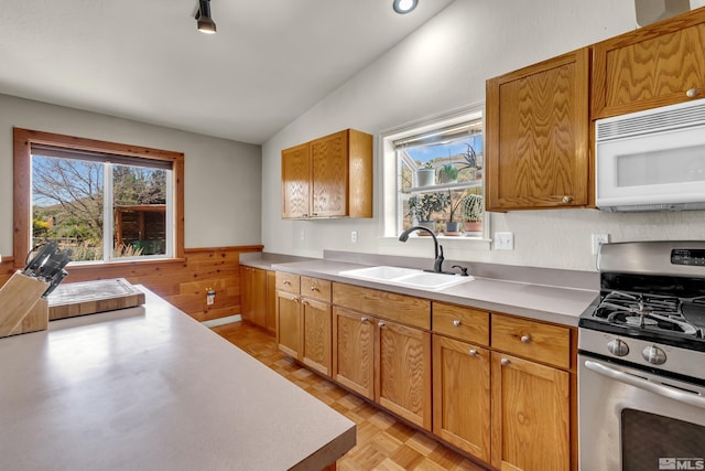 14865 N Red Rock Rd, Reno, NV 89508 - kitchen with stainless steel range with gas stovetop, white microwave, a sink, vaulted ceiling, and light countertops