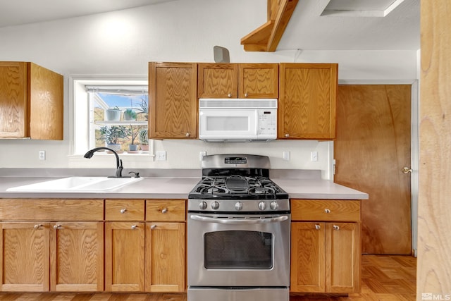 14865 N Red Rock Rd, Reno, NV 89508 - kitchen with gas range, white microwave, a sink, light countertops, and brown cabinets