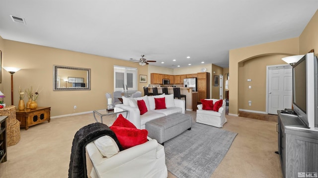 1230 Quail Run Dr, Carson City, NV 89701 - living room with light carpet, ceiling fan, arched walkways, baseboards, and recessed lighting