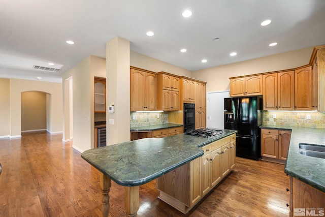 1745 Hunter Creek Rd, Reno, NV 89519 - kitchen with black appliances, a center island, arched walkways, tasteful backsplash, and recessed lighting
