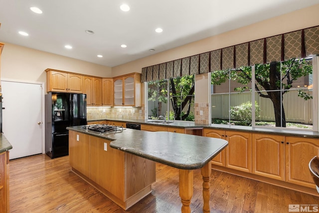 1745 Hunter Creek Rd, Reno, NV 89519 - kitchen featuring black appliances, a center island, dark countertops, glass insert cabinets, and recessed lighting