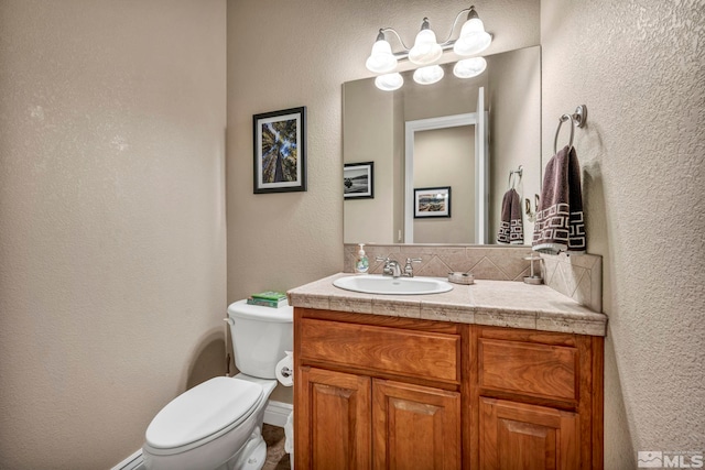 2825 N Fork Ln, Minden, NV 89423 - half bathroom featuring a textured wall, vanity, and toilet
