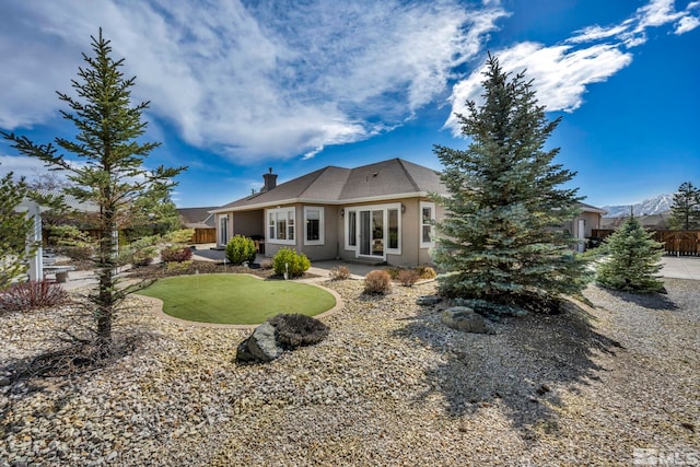 2825 N Fork Ln, Minden, NV 89423 - rear view of property with an area to practice putting, a patio area, fence, stucco siding, and a chimney