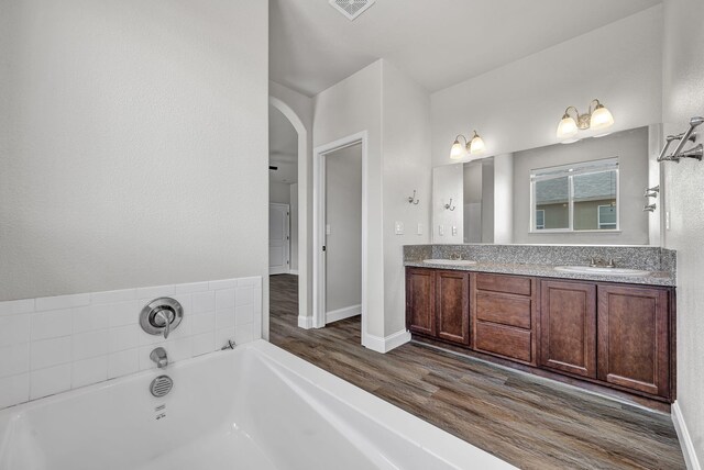 1282 Onda Verde Dr, Fallon, NV 89406 - bathroom with wood finished floors, double vanity, a garden tub, and baseboards
