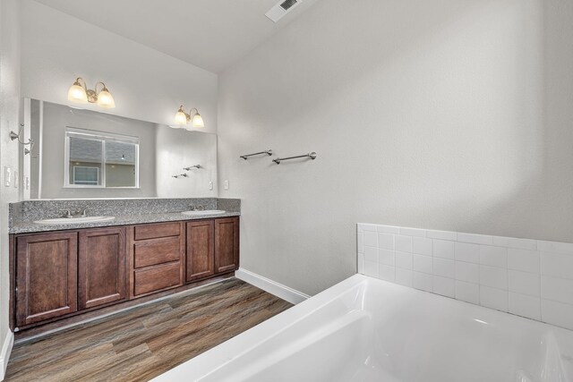 1282 Onda Verde Dr, Fallon, NV 89406 - bathroom featuring wood finished floors, a bath, double vanity, and baseboards