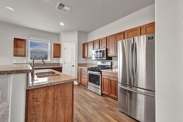 1282 Onda Verde Dr, Fallon, NV 89406 - kitchen with appliances with stainless steel finishes, a sink, light wood-style floors, brown cabinets, and recessed lighting