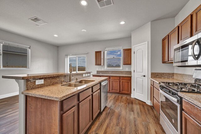 1282 Onda Verde Dr, Fallon, NV 89406 - kitchen with stainless steel appliances, a sink, dark wood-style floors, brown cabinets, and recessed lighting