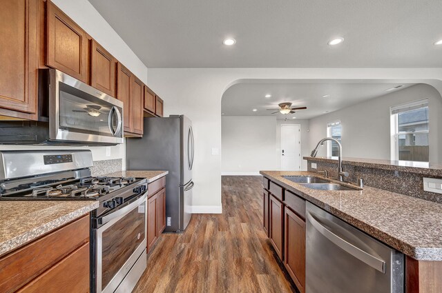 1282 Onda Verde Dr, Fallon, NV 89406 - kitchen featuring appliances with stainless steel finishes, a sink, arched walkways, ceiling fan, and dark wood-type flooring