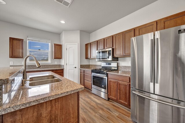 1282 Onda Verde Dr, Fallon, NV 89406 - kitchen featuring stainless steel appliances, a sink, light wood-style flooring, brown cabinets, and recessed lighting