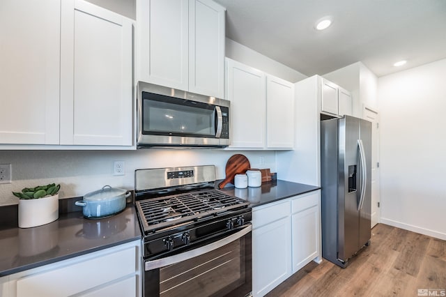 7593 Apex Pl Lot # 109, Reno, NV 89506 - kitchen with stainless steel appliances, dark countertops, light wood-style floors, white cabinetry, and recessed lighting