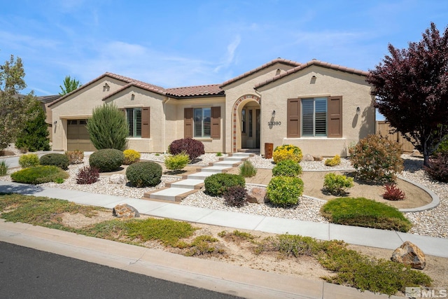 mediterranean / spanish-style house with a tiled roof, stucco siding, a garage, and fence