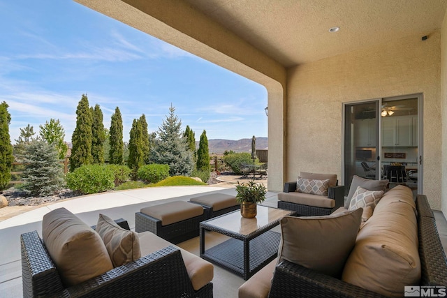 view of patio with an outdoor living space and a mountain view