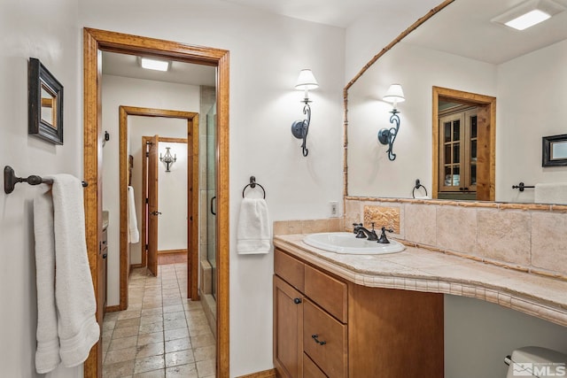 671 14th Green Dr, Incline Village, NV 89451 - bathroom with baseboards, vanity, a shower stall, stone tile floors, and tasteful backsplash