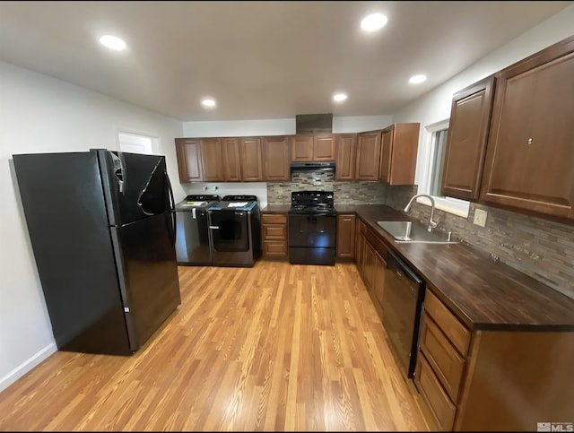 4621 Aster Dr, Reno, NV 89502 - kitchen with black appliances, washer and dryer, a sink, dark countertops, and light wood finished floors