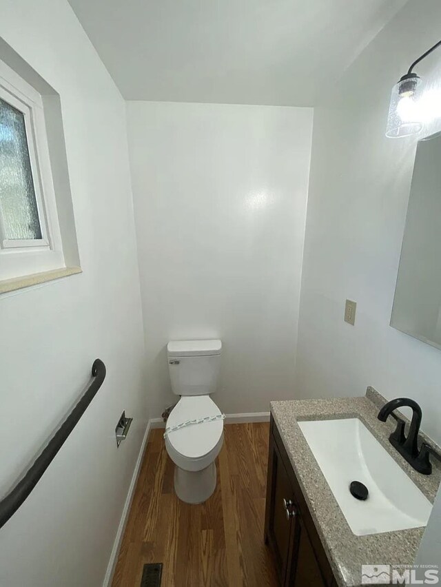4621 Aster Dr, Reno, NV 89502 - half bathroom with vanity, wood finished floors, toilet, and baseboards