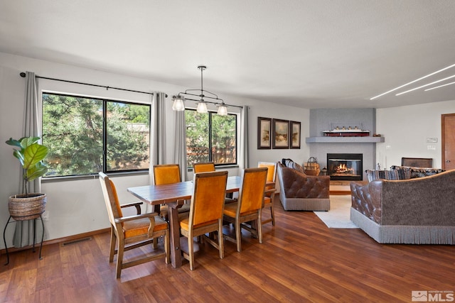 3075 Markridge Dr, Reno, NV 89509 - dining room featuring wood finished floors, a glass covered fireplace, and baseboards