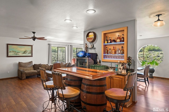 3075 Markridge Dr, Reno, NV 89509 - indoor wet bar featuring dark wood-type flooring, ceiling fan, a textured ceiling, and baseboards