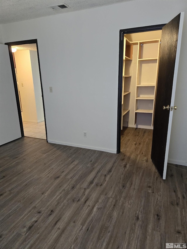 4604 Neil Rd Unit 157, Reno, NV 89502 - unfurnished bedroom with dark wood finished floors, a walk in closet, baseboards, and a closet