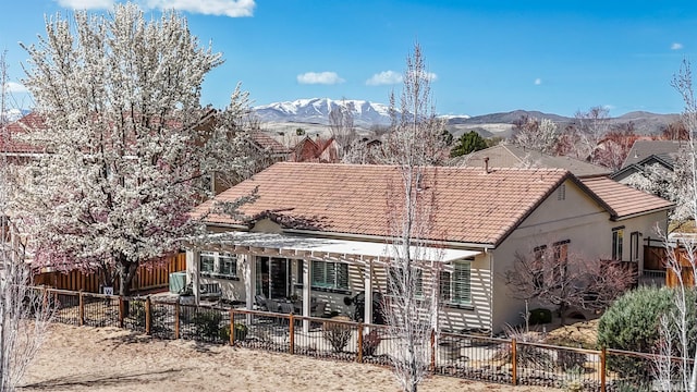 6650 Magical Dr, Sparks, NV 89436 - back of property with a tile roof, a pergola, a fenced backyard, and a mountain view
