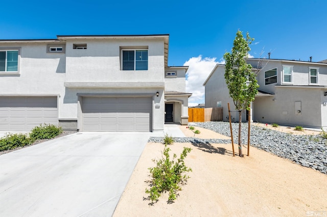 8855 Wolf Moon Dr, Reno, NV 89506 - view of front of house featuring stucco siding, driveway, fence, and a garage