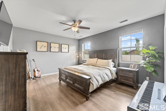 bedroom featuring wood finished floors, baseboards, and a ceiling fan