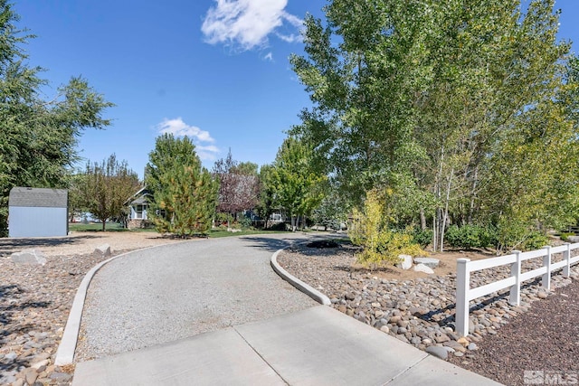 view of home's community featuring an outbuilding, a storage shed, and fence