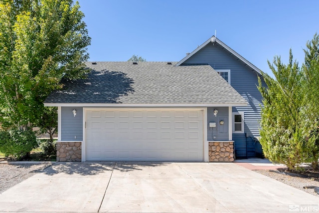 view of front of home with a shingled roof, stone siding, and driveway