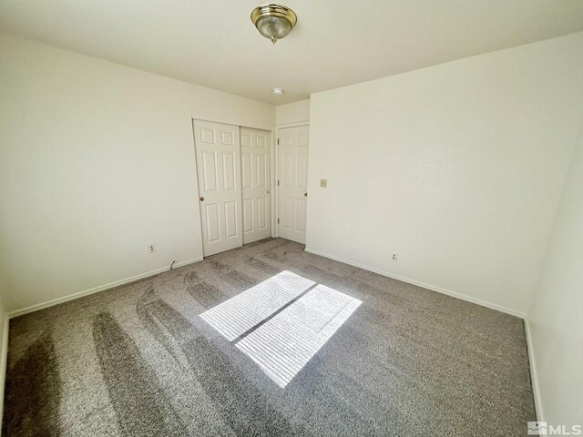 1447 N Marion Russell, Gardnerville, NV 89410 - unfurnished bedroom featuring carpet flooring, a closet, and baseboards