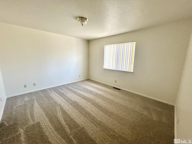 1447 N Marion Russell, Gardnerville, NV 89410 - empty room featuring carpet flooring, baseboards, and a textured ceiling