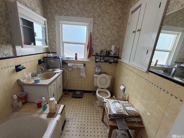 100 Dalton St, Fallon, NV 89406 - bathroom with a wainscoted wall, wallpapered walls, tile walls, vanity, and a bathtub