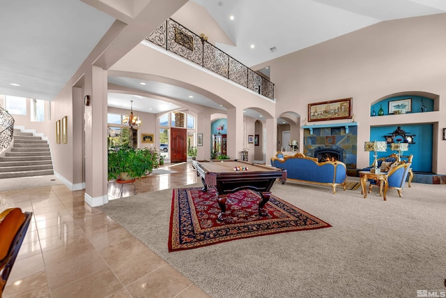 10401 Copper Cloud Dr, Reno, NV 89511 - rec room featuring billiards table, healthy amount of natural light, a lit fireplace, arched walkways, and a high ceiling