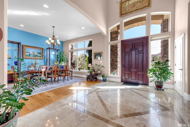 10401 Copper Cloud Dr, Reno, NV 89511 - entryway with baseboards, a chandelier, arched walkways, inlaid floor details, and a towering ceiling