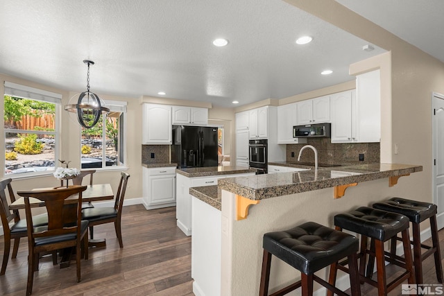 2963 Moose Ridge Dr, Reno, NV 89523 - kitchen featuring black appliances, a peninsula, dark wood finished floors, tasteful backsplash, and a kitchen bar