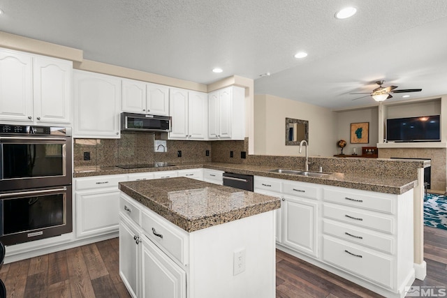 2963 Moose Ridge Dr, Reno, NV 89523 - kitchen with black appliances, a sink, a peninsula, dark wood-type flooring, and recessed lighting