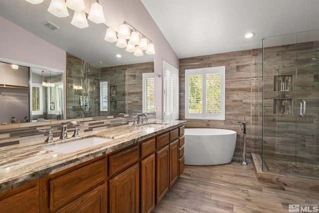 2963 Moose Ridge Dr, Reno, NV 89523 - bathroom featuring lofted ceiling, a shower stall, double vanity, a freestanding bath, and wood finished floors