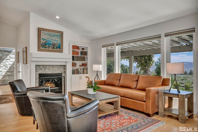 14250 Quiet Meadows Dr, Reno, NV 89511 - living area featuring a warm lit fireplace, light wood-type flooring, lofted ceiling, recessed lighting, and built in features
