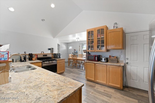 391A Bens Way, Fernley, NV 89408 - kitchen with stainless steel gas range, a sink, light wood-style flooring, glass insert cabinets, and light stone counters