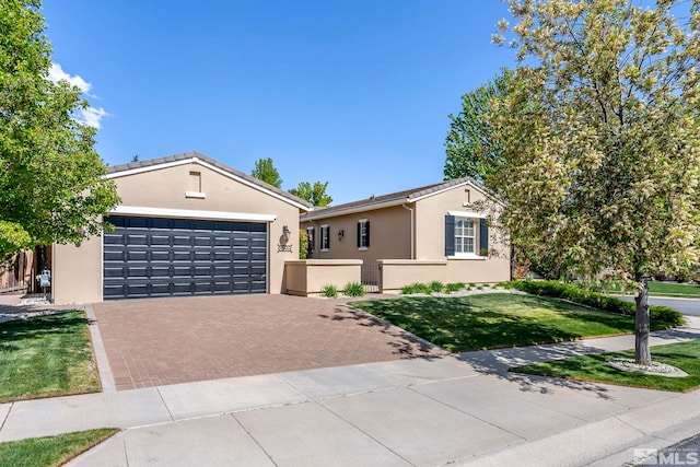single story home featuring decorative driveway, stucco siding, a front yard, and an attached garage