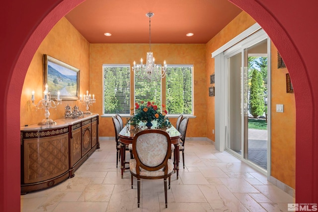 dining space featuring stone tile flooring, a chandelier, healthy amount of natural light, and recessed lighting