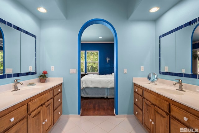 ensuite bathroom featuring two vanities, tile patterned flooring, recessed lighting, and baseboards