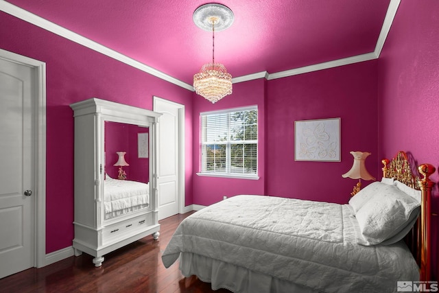 bedroom with a chandelier, crown molding, wood finished floors, and baseboards
