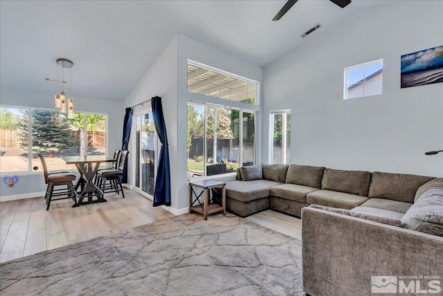 7766 Cerritos Cir, Sparks, NV 89436 - living room featuring wood finished floors, a ceiling fan, high vaulted ceiling, baseboards, and a chandelier