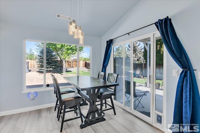 7766 Cerritos Cir, Sparks, NV 89436 - dining space featuring a chandelier, vaulted ceiling, light wood finished floors, and baseboards