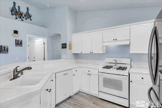 7766 Cerritos Cir, Sparks, NV 89436 - kitchen featuring white appliances, under cabinet range hood, a sink, white cabinetry, and light wood-style flooring