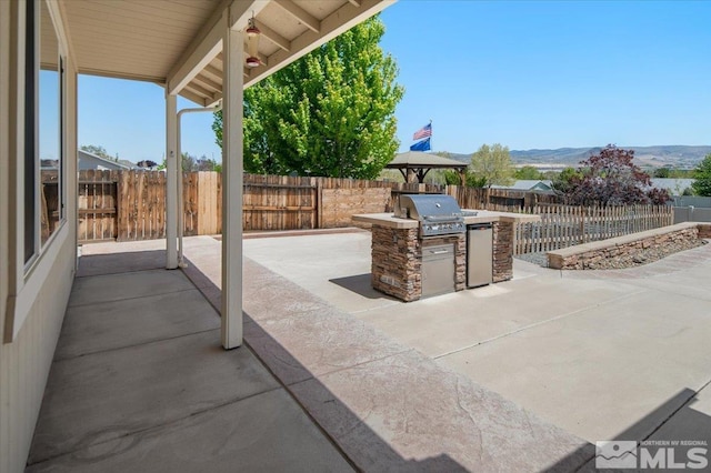2160 Mammatus Dr, Sparks, NV 89441 - view of patio / terrace featuring a grill, exterior kitchen, a fenced backyard, and a mountain view