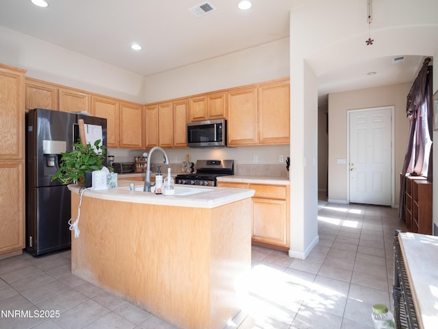 1840 Granite Chief Dr, Reno, NV 89521 - kitchen featuring stainless steel appliances, light tile patterned floors, light brown cabinets, light countertops, and a kitchen island with sink