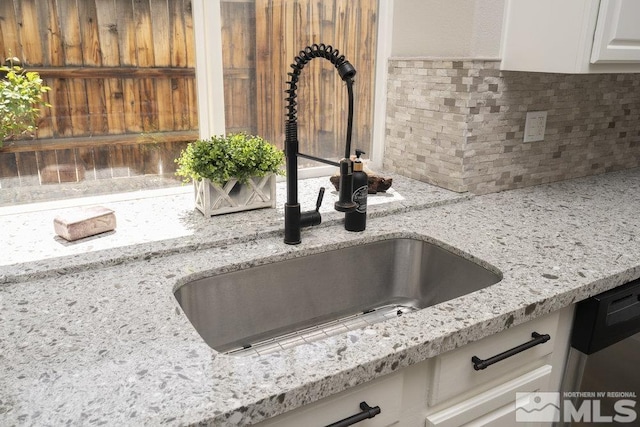4822 Ramcreek Trl, Reno, NV 89519 - kitchen view of a sink, backsplash, light stone countertops, and white cabinets