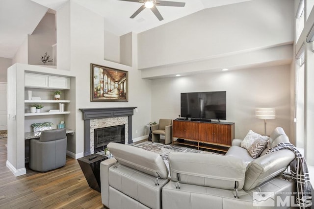 4822 Ramcreek Trl, Reno, NV 89519 - living room with a ceiling fan, wood finished floors, high vaulted ceiling, a high end fireplace, and baseboards