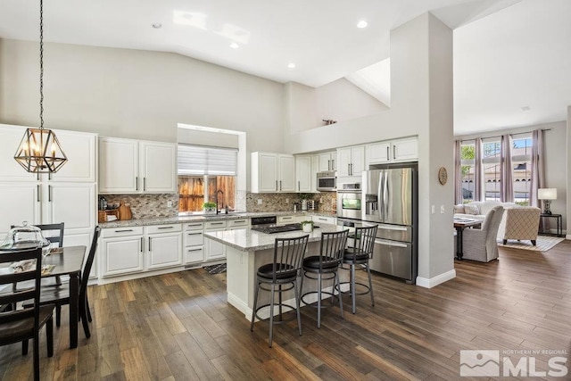 4822 Ramcreek Trl, Reno, NV 89519 - kitchen with appliances with stainless steel finishes, high vaulted ceiling, white cabinets, a sink, and a chandelier